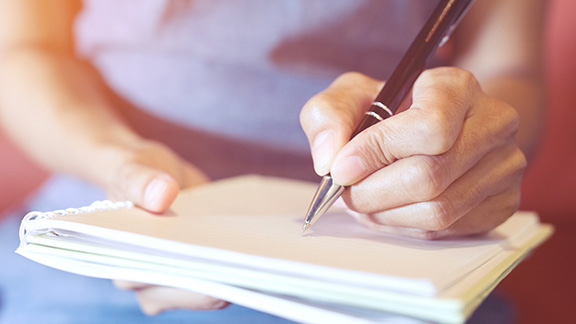 person writing on paper book